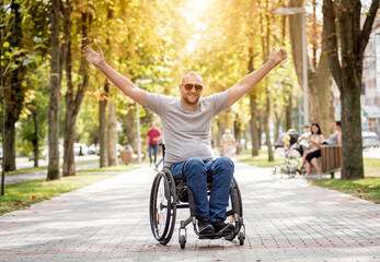 Handicapped man in wheelchair walk at the park alley