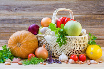 Fresh ripe vegetables in a wicker basket on a wooden table
