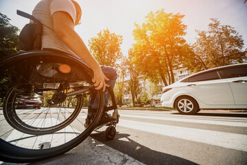 Handicapped man in wheelchair crossing street road