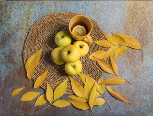 Still life of golden apples and hot infusion in yellow cup