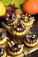 Pumpkin muffins with chocolate. Autumn desserts. Autumn composition with poke and cupcakes. Autumn mood.