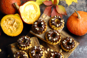 Pumpkin muffins with chocolate. Autumn desserts. Autumn composition with poke and cupcakes. Autumn mood.