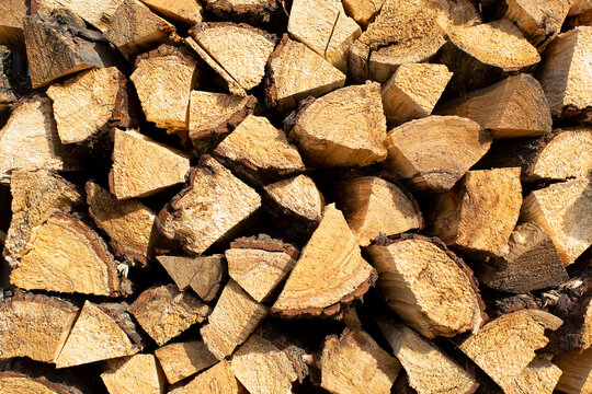 Background of firewood stack close up, wood stack texture, stacked logs texture