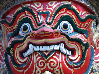 Bangkok, Thailand, January 25, 2013: Close-up of the red face of a warrior sculpture at the Royal Palace in Bangkok