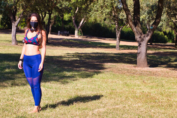 young woman with black mask preparing to do session yoga