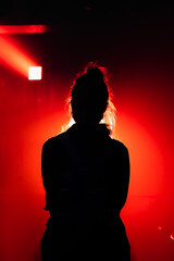 Silhouette of woman under red spotlight