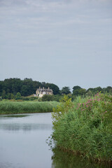 A traditional English thatched house on a bend in a tranquil river