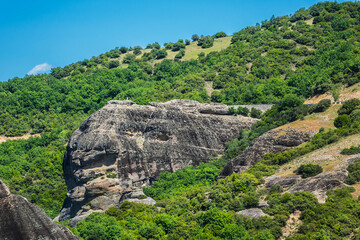 Fototapeta na wymiar Rock cliffs (60 million years old) in deltaic plains of Meteora. Cliffs rise to a height of 400 meters. They situated in Pineios Valley within Thessalian plains close to town of Kalambaka. Greece.