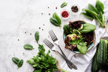 Healthy veggie salad with spinach, red lettuce, cucumbers and greenery top view flat lay