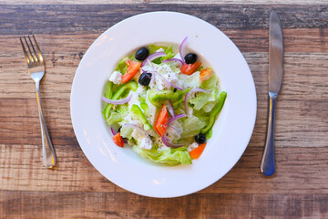 top view of greek salad in a bowl on table.