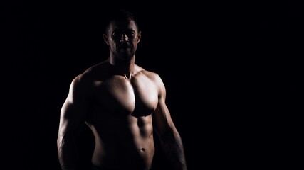 Obraz na płótnie Canvas Fit and sporty bodybuilder over black background. Sportsman in studio. Sport and fitness concepts.