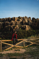 Fototapeta na wymiar Chico joven con camisa roja estilo leñador en parque natural cerro del hierro,sevilla