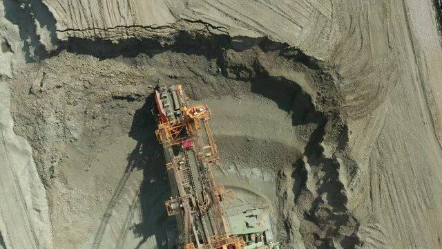 Aerial view of bucket wheel excavator in process of mining natural resource. Heavy industry.