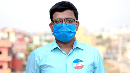 Man puts I Voted sticker with American Flag on the shirt.