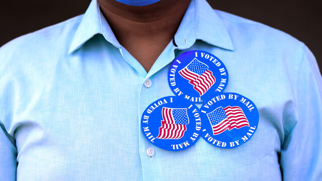 Voting Fraud Concept. Lack of trustworthiness for Mail-in voting. Man puts multiple I Voted By Mail stickers on the shirt.
