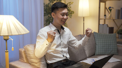overjoyed male engineer running a test on notebook computer and waving fist happily cheering for...