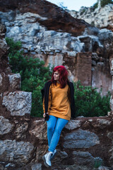 Chica peliroja en parque natural tomando fotogarfías 