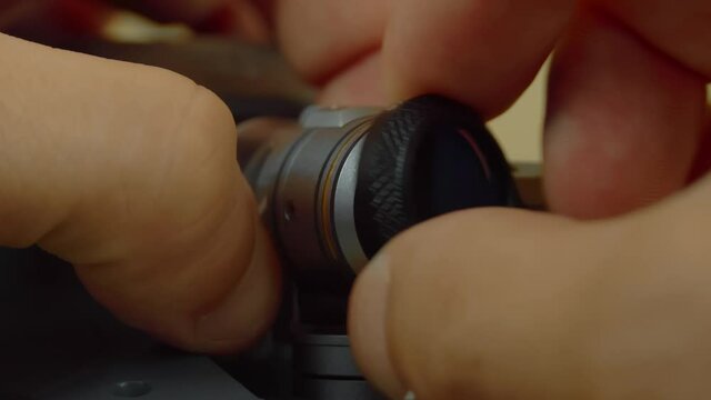 A close-up shot of a hand holding an nd or pl neutral density filter for unmanned cameras, drones, or copters.