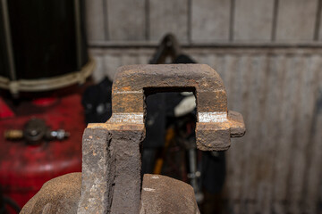 Rusty brake caliper after removing the rust, attached to a bench vise.