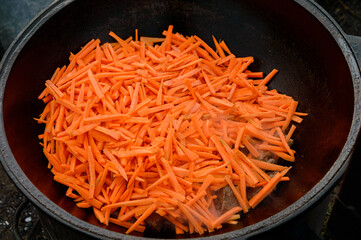 meat in a cauldron with carrots and onions