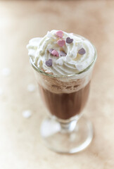Coffee with whipped cream on bright stone background. Soft focus. Close up. 