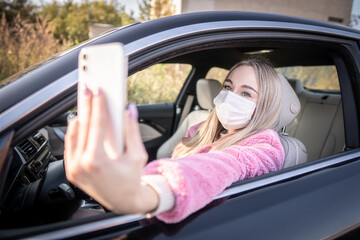 Naklejka premium Young woman as a road pirat wearing protect face mask is making a selfie photo during driving her sport car. 