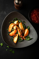 Roasted potatoes with mushrooms and basil on a plate