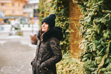 Seasonal outdoor portrait of happy young woman enjoying nice sunny winter day