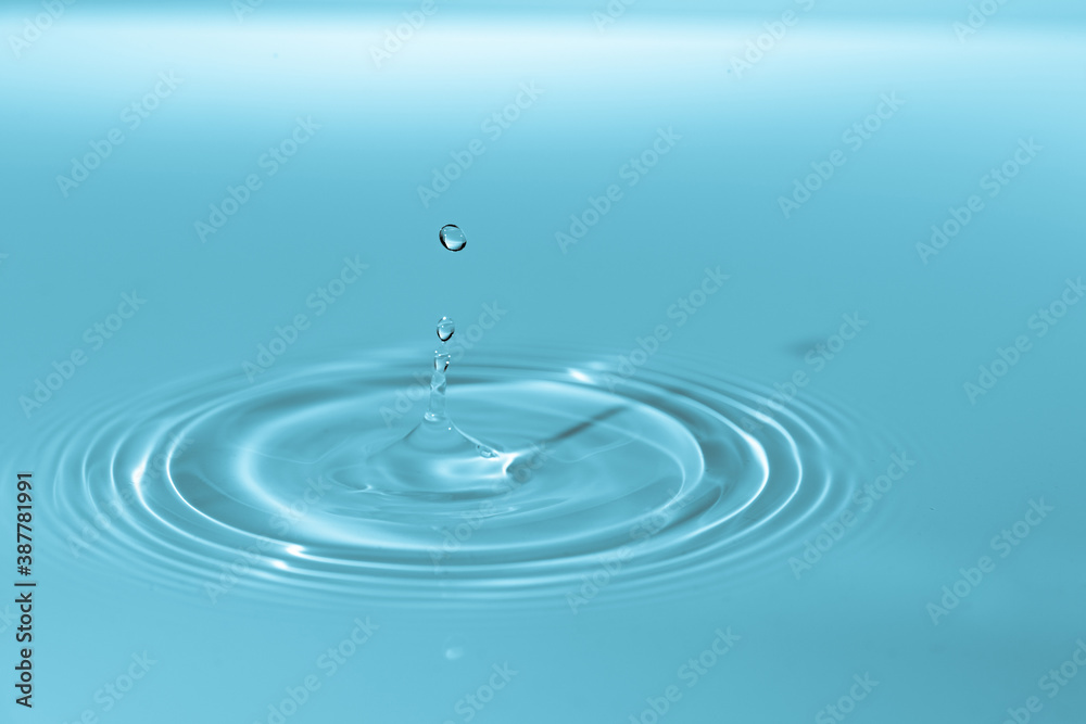 Wall mural drop of water drop to the surface. waves on the surface of the water from a collision