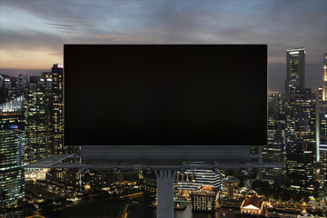 Blank black road billboard with Singapore cityscape background at night time. Street advertising poster, mock up, 3D rendering. Front view. The concept of marketing communication to sell idea. © VideoFlow