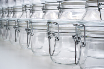 Several empty glass jars with lip-top closures in a zero waste shop, selective focus