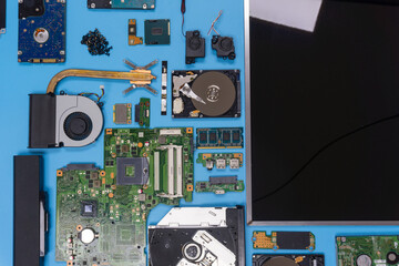 Parts of a modern computer. The insides of a laptop on a blue background, flat lay composition