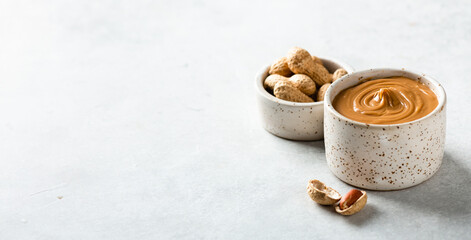 peanut butter in a ceramic bowl on a light background, copy space, banner