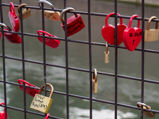Fototapeta Cadenas rouge et en forme de coeur accrochés à un pont : Promesse d'amour et de fidélité obraz