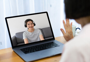 senior asian woman using computer to video call and talk with daughter from home