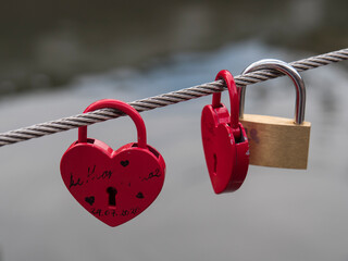 Cadenas rouge et en forme de coeur accrochés à un pont : Promesse d'amour et de fidélité