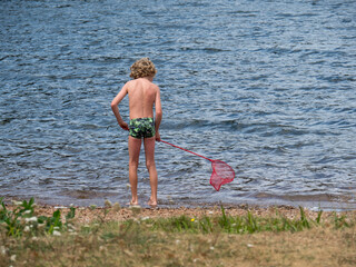 Enfant jouant avec une épuisette à la plage