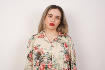 Gloomy, bored girl frowns face looking up, being upset with so much talking hands down, feels tired and wants to leave. Angry sullen woman standing indoors.