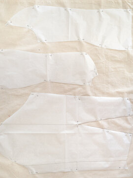 Top View Of Paper Pattern Layouts Of Dress On Calico Fabric