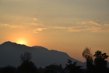 sun set with clouds, yellow sky and nature surroundings.