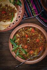 Vegan picadillo and tacos made with seitan, cabbage, spices, on wooden table in traditional serving bowls
