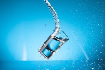 splash from falling glasses with water on blue background
