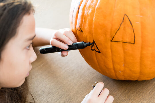 Fillette r&eacute;alisant une lanterne d'Halloween