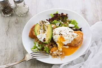 A healthy and balanced breakfast plate.
Benedict's egg spreads on a toasted toast with half an avocado, quinoa and lettuce, seasoned   spices and yogurt dressing. Enjoy the most important meal of the 