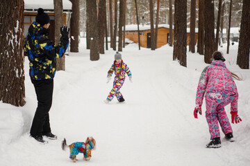 Family in the winter park having fun and playing