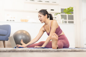 Fitness coach teaching yoga online to group of people. Young asian girl beginning yoga practice with private teacher via video conference.