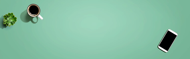 Smartphone with a coffee mug and succulent plant - flat lay