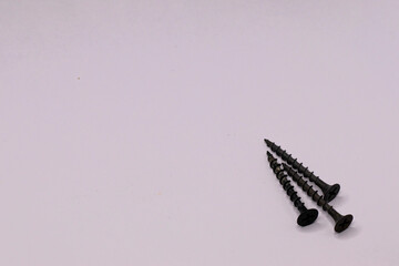 Black three self-tapping screws on wood.