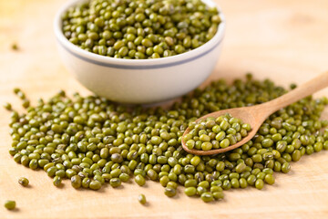 Mung bean in a bowl and spoon on wooden background