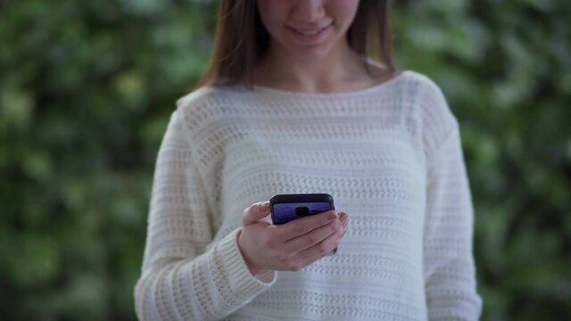 Woman holding mobile phone in her hands and texting message, sufring social network